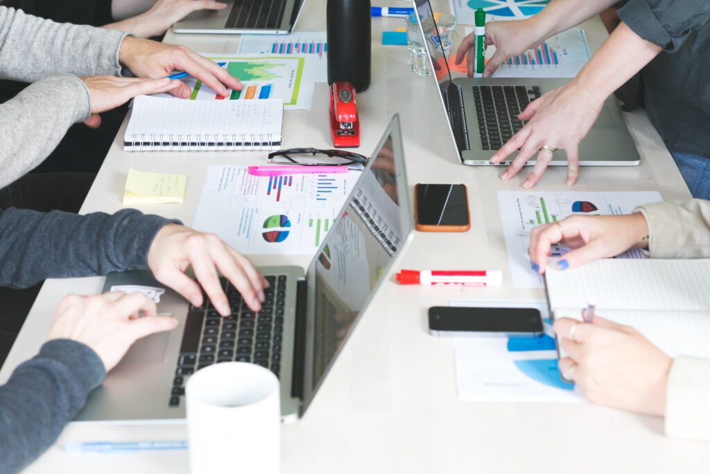 People working on laptops around a conference table