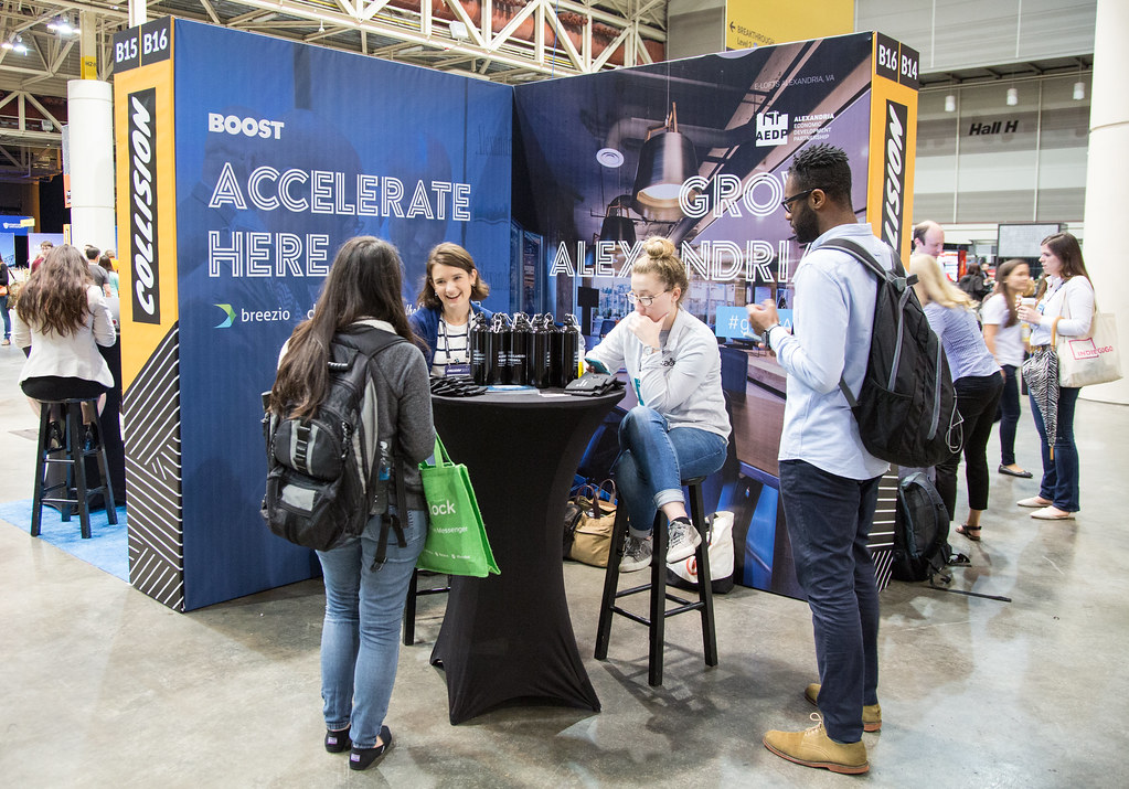 People engaging at a trades show booth, for about us Snap field marketing