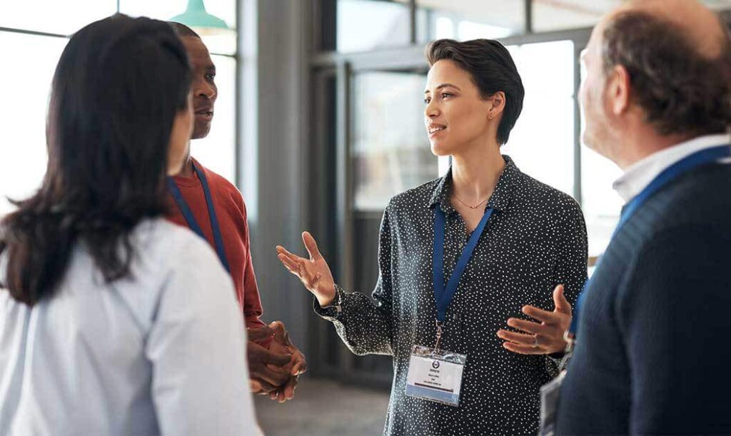 4 people wearing badges talking at a conference